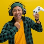 A man wearing headphones and holding a video game controller