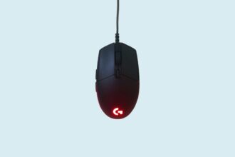 Logitech G335 Gaming-Headset in einer auffälligen Farbe auf einem schwarzen Schreibtisch mit Tastatur und Maus.