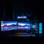 Ein Gaming-Monitor mit gekrümmtem WQHD-Display, hoher Bildwiederholrate und RGB-Beleuchtung auf einem Schreibtisch mit Tastatur und Maus.