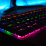 Ein breiter Gaming-Monitor mit gekrümmtem UltraWide-Display, der den Spieler in leuchtenden Farben umgibt, während ein Preisaufkleber im Fokus steht.