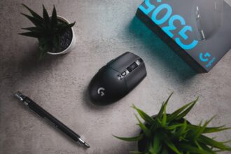 Close-up eines Logitech G502 HERO Gaming-Maus mit RGB-Beleuchtung, das auf einem Mauspad liegt, um das 25.600 DPI Sensor-Upgrade und die 11 programmierbaren Tasten zu zeigen.